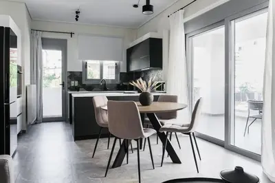 a kitchen with a table and chairs in a room at Teal Faliro House by UPSTREET in Athens