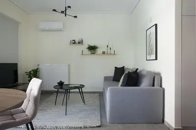 a living room with a couch and a table at Teal Faliro House by UPSTREET in Athens