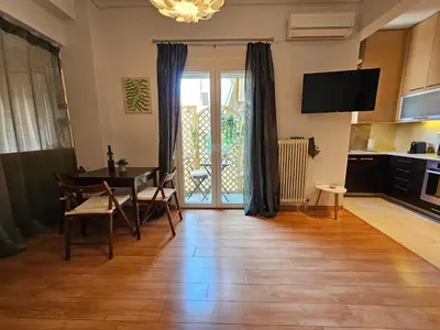 a living room with a dining room table and a kitchen at Acropolis Museum Suite by YHA in Athens