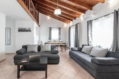 a living room with a couch and a table at Blue Riviera villas & suites - Alimos 2 in Athens