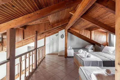 a attic room with two beds and a balcony at Blue Riviera villas & suites - Alimos 2 in Athens