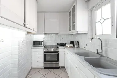 a white kitchen with a stove and a sink at Blue Riviera villas & suites - Alimos 2 in Athens
