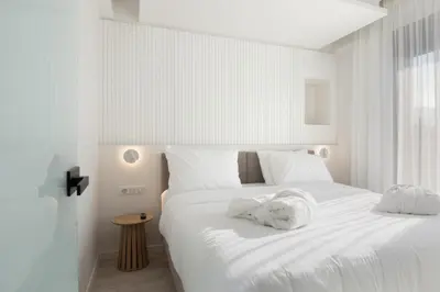 a bedroom with a white bed with a towel on it at Incanto Boutique Suites - Mets in Athens
