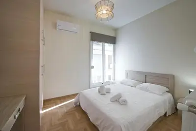a bedroom with a white bed with two towels on it at Koukaki Gem Cozy 1BR Renovated Apt near Center in Athens
