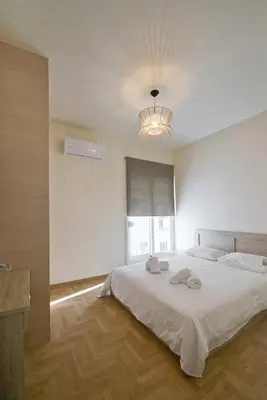 a bedroom with a large white bed with a ceiling at Koukaki Gem Cozy 1BR Renovated Apt near Center in Athens