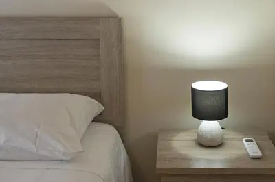 a lamp on a table next to a bed at Koukaki Gem Cozy 1BR Renovated Apt near Center in Athens