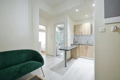 a living room with a green couch and a kitchen at Koukaki Gem Cozy 1BR Renovated Apt near Center in Athens