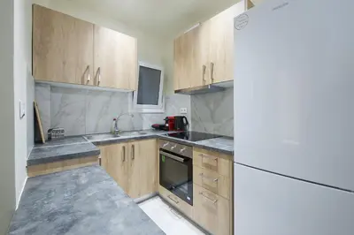 a kitchen with wooden cabinets and a white refrigerator at Koukaki Gem Cozy 1BR Renovated Apt near Center in Athens