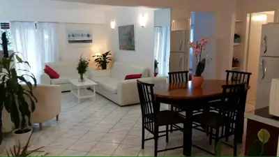 a living room with a table and chairs and a couch at Flor de Mayo,Apt in Alimos near the sea in Athens