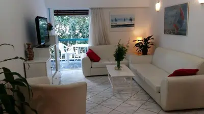 a living room with a couch and a table at Flor de Mayo,Apt in Alimos near the sea in Athens