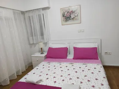 a bedroom with a large bed with purple pillows at Flor de Mayo,Apt in Alimos near the sea in Athens