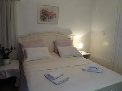 a bedroom with a white bed with two towels on it at Flor de Mayo,Apt in Alimos near the sea in Athens