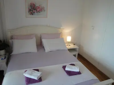 a bedroom with a white bed with two towels on it at Flor de Mayo,Apt in Alimos near the sea in Athens