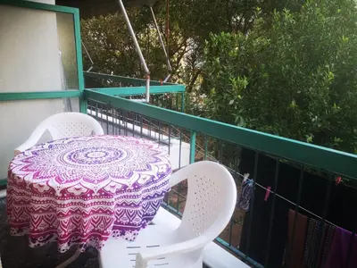 a purple and white table and chairs on a balcony at Flor de Mayo,Apt in Alimos near the sea in Athens