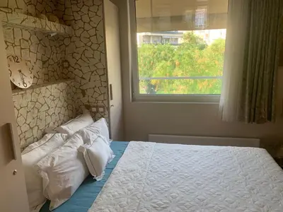 a bedroom with a bed with white pillows and a window at Zen home in Athens