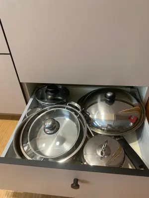 a stove top with pots and pans in a drawer at Zen home in Athens