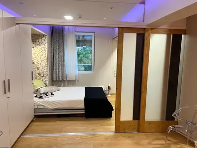 a bedroom with a bed and a window with purple lighting at Zen home in Athens