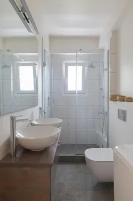 a bathroom with two sinks and a shower and a toilet at Seaside Bliss Flat in Saronida