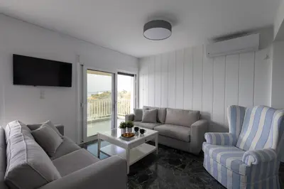a living room with a couch and two chairs and a table at Seaside Bliss Flat in Saronida
