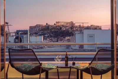 a table and chairs on a balcony with a view ofhens at Acropolis View Mini Sky Suite & Hot Tub in Athens