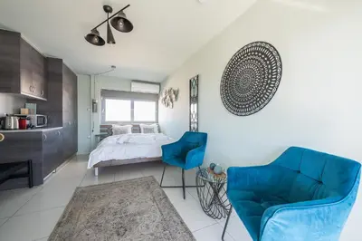 a bedroom with a bed and a blue chair at Acropolis View Mini Sky Suite & Hot Tub in Athens
