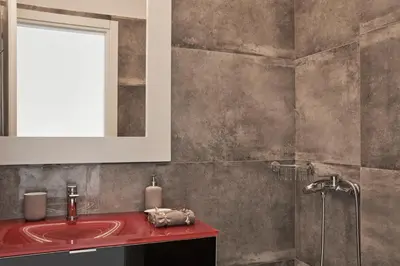 a bathroom with a red sink and a shower at Augoustos ECO luxury apartments with pool in Aghia Marina