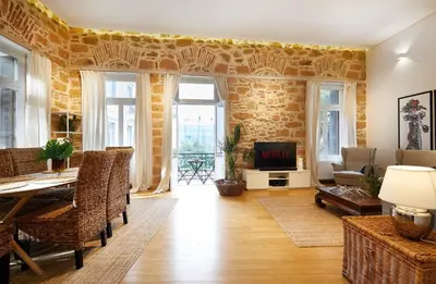 a living room with a brick wall and a table and chairs at Chloe Boutique Apartments Plaka in Athens