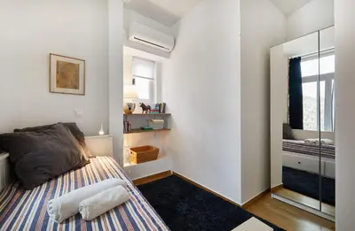 a small bedroom with a bed and a mirror at Chloe Boutique Apartments Plaka in Athens
