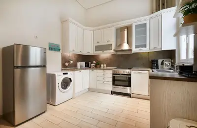 a kitchen with white cabinets and a stainless steel refrigerator at Chloe Boutique Apartments Plaka in Athens