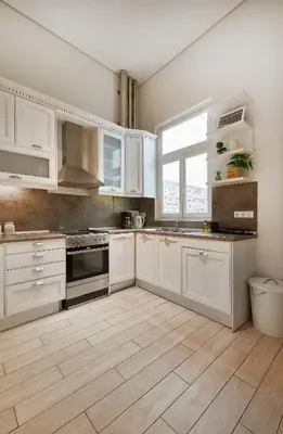 a kitchen with white cabinets and a wooden floor at Chloe Boutique Apartments Plaka in Athens