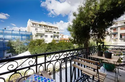a balcony with two benches and a table on a fence at Chloe Boutique Apartments Plaka in Athens