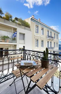 a wooden bench sitting on a balcony with a cactus at Chloe Boutique Apartments Plaka in Athens