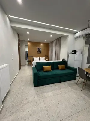 a living room with a green couch in front of a bed at Smart Lux Apartment B in Athens