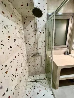 a bathroom with a shower with a rock wall at Smart Lux Apartment B in Athens