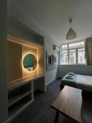 a bedroom with a bed and a table and a mirror at Monastiraki 101 SuperHost Hub in Athens