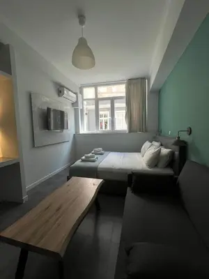 a bedroom with a bed and a couch and a table at Monastiraki 101 SuperHost Hub in Athens