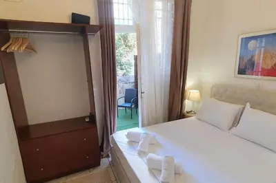 a bedroom with a white bed and a large window at Lefti's Cosy Studio 40m2, Metro 7' in Athens
