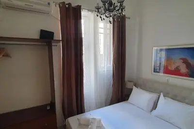 a bedroom with a white bed and a window at Lefti's Cosy Studio 40m2, Metro 7' in Athens
