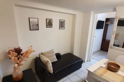 a living room with a black couch and a table at Lefti's Cosy Studio 40m2, Metro 7' in Athens