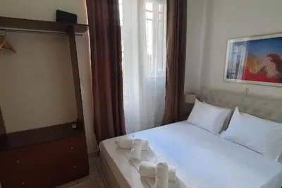 a bedroom with a bed with white sheets and pillows at Lefti's Cosy Studio 40m2, Metro 7' in Athens