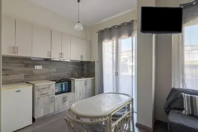 a kitchen with a table and a tv in a room at Lovely Studio Apartment For 2 Ppl in Athens in Athens