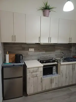 a kitchen with white cabinets and a stove top oven at Lovely Studio Apartment For 2 Ppl in Athens in Athens