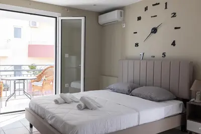 a bedroom with a bed with a clock on the wall at AIOLOS LUXURY agios dimitrios center apartment 4 in Athens