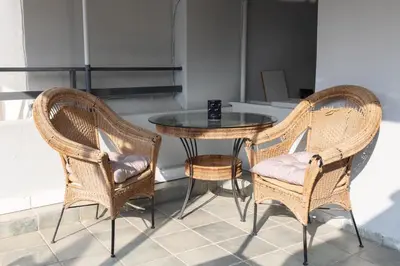 two wicker chairs and a glass table in a room at AIOLOS LUXURY agios dimitrios center apartment 4 in Athens