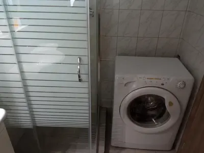 a small bathroom with a washing machine in a stall at AIOLOS LUXURY agios dimitrios center apartment 4 in Athens