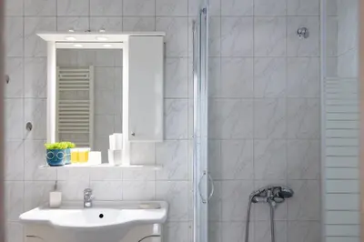 a white bathroom with a sink and a mirror at AIOLOS LUXURY agios dimitrios center apartment 4 in Athens