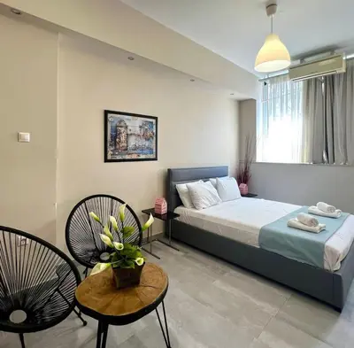 a bedroom with a bed and two chairs and a table at Monastiraki 103 SuperHost Hub in Athens