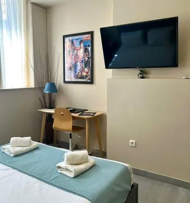 a room with a bed and a desk and a television at Monastiraki 103 SuperHost Hub in Athens