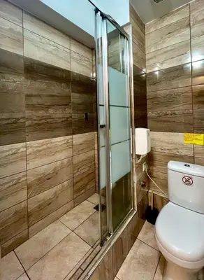a bathroom with a toilet and a glass shower at Monastiraki 103 SuperHost Hub in Athens
