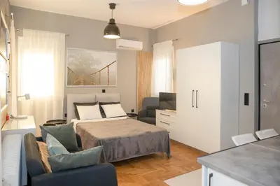 a bedroom with a bed and a couch and a bridge at Rooftop studio with private terrace at Lycabettus Hill in Athens